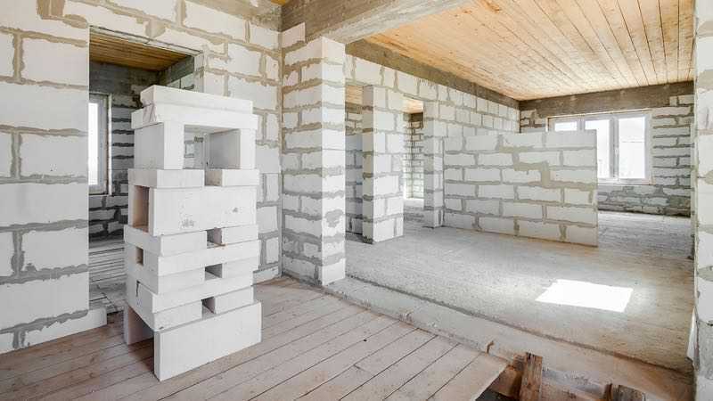 Pièce avec plafond en bois et murs non plâtrés