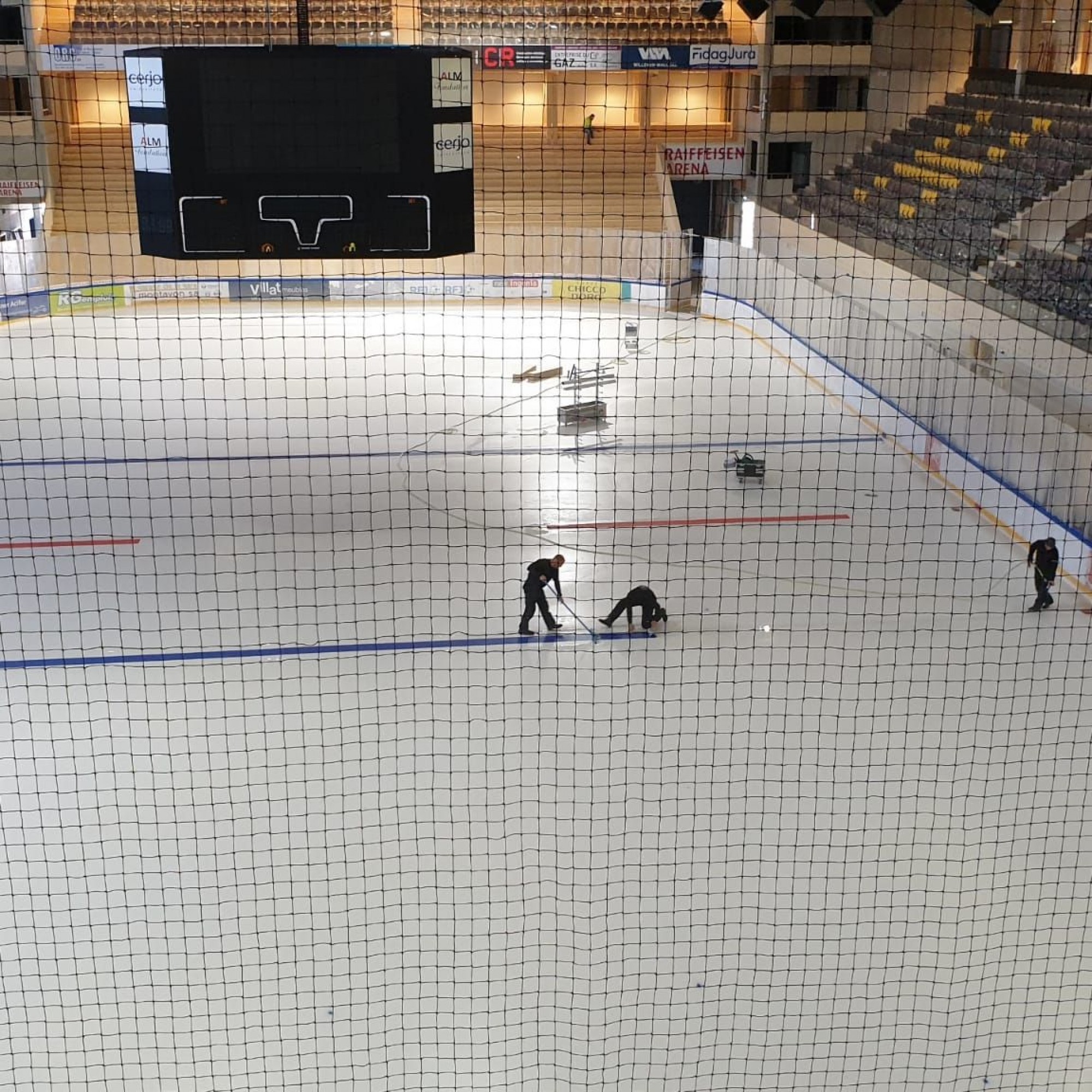 Vu des gradins réservés aux supporters locaux, une surface de glace munie de loges et de divers locaux. 