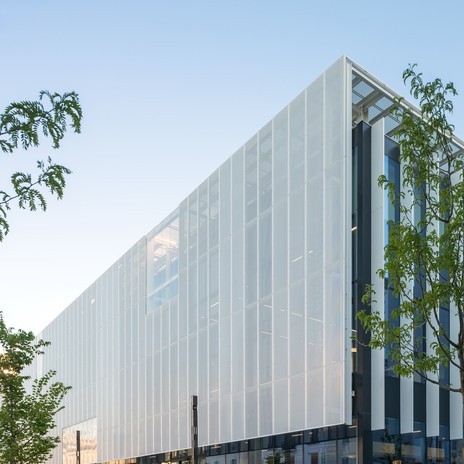 L'halle s’habille d’une enveloppe unitaire, en façade comme en toiture, constituée d’une résille métallique blanche aux perforations  permettant un apport de lumière à l'intérieur.