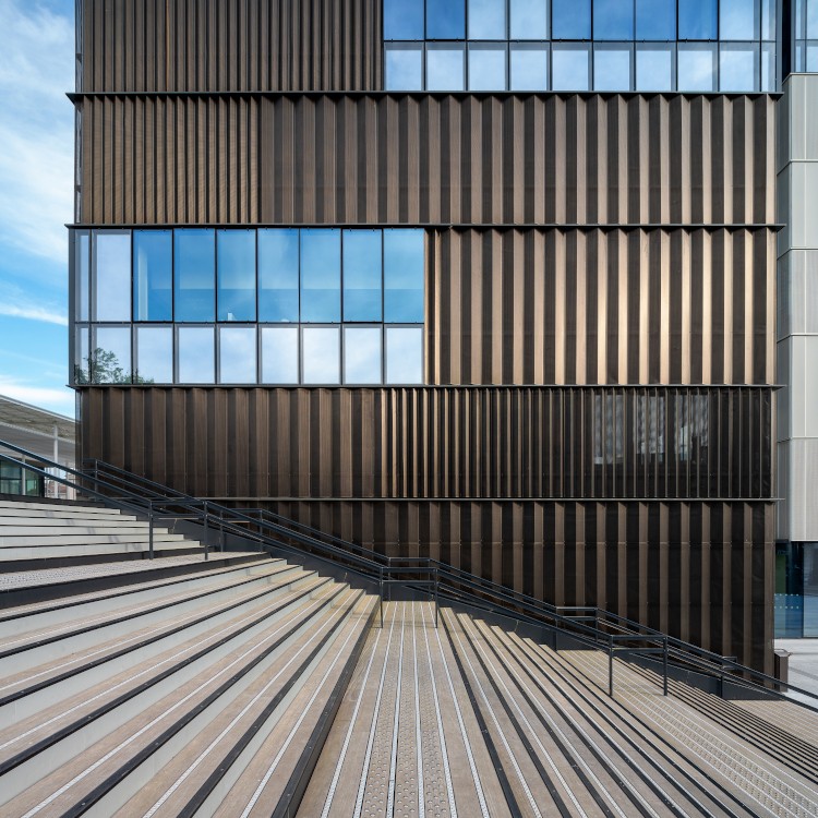 Au premier étage, la mezzanine intérieure de la halle se prolonge par une terrasse extérieure en bois.