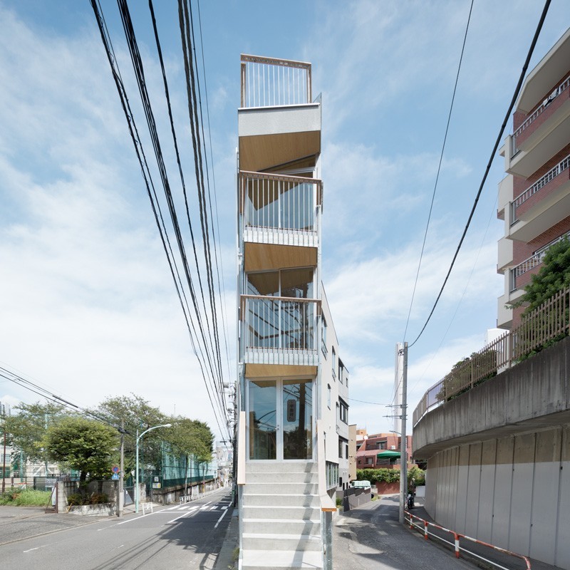 L'effet sculptural de la façade d'entrée très étroite est trompeur, car le bâtiment comprend des petits bureaux et un magasin en plus des appartements.