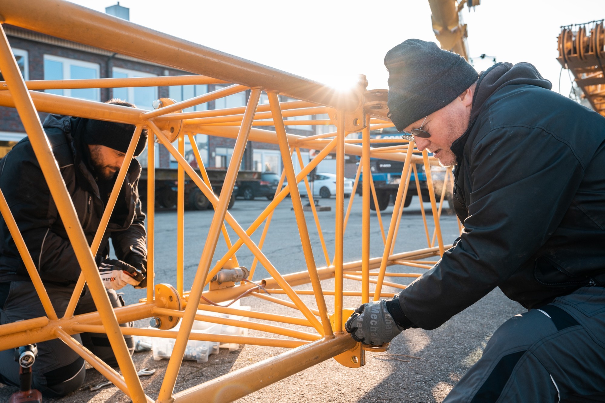 Stephan Keim et les techniciens Liebherr assemblent la grue qui a été démontée pour être transportée.