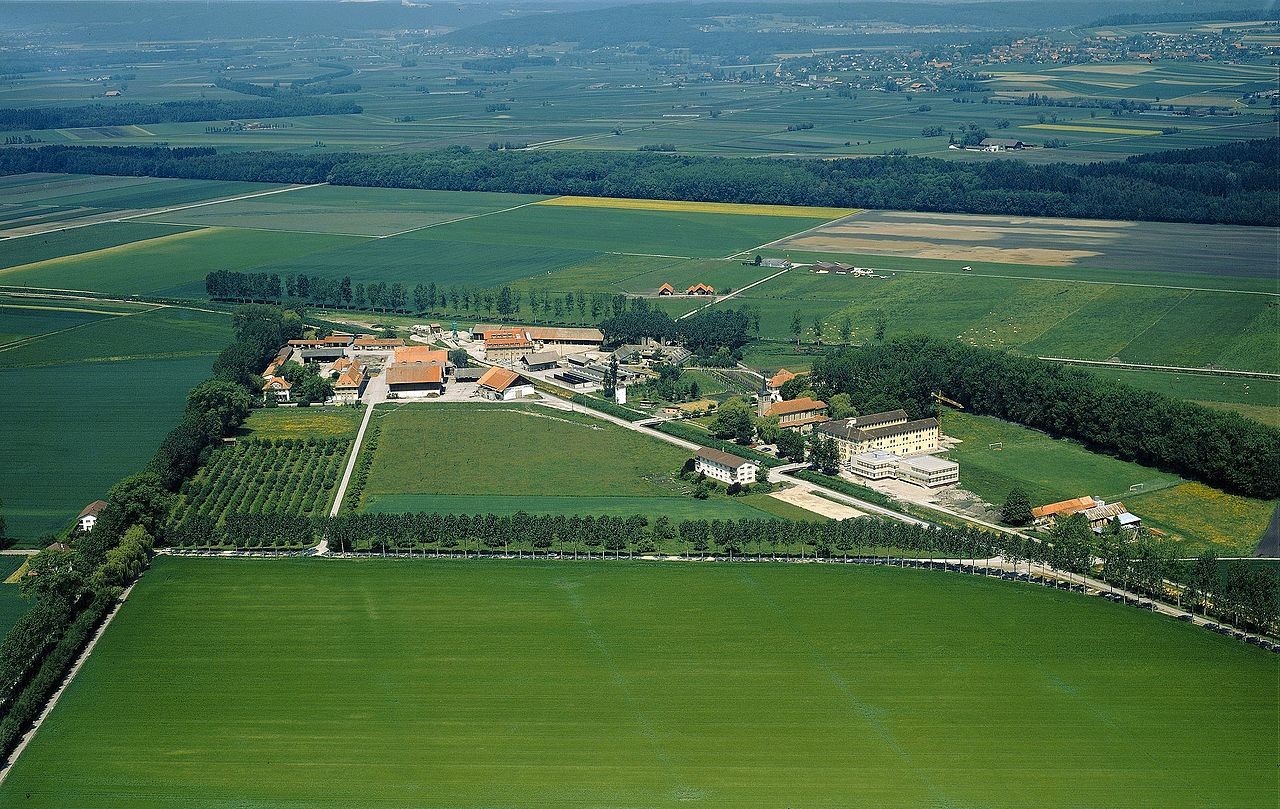 Vue du pénitencier datant de 1987. Le complexe pénitentiaire de Sugiez a une occupation actuelle de 203 places au total. Avec plus de 700 ha (2ème domaine de Suisse en surface), l'exploitation agricole constitue un élément clé du site.