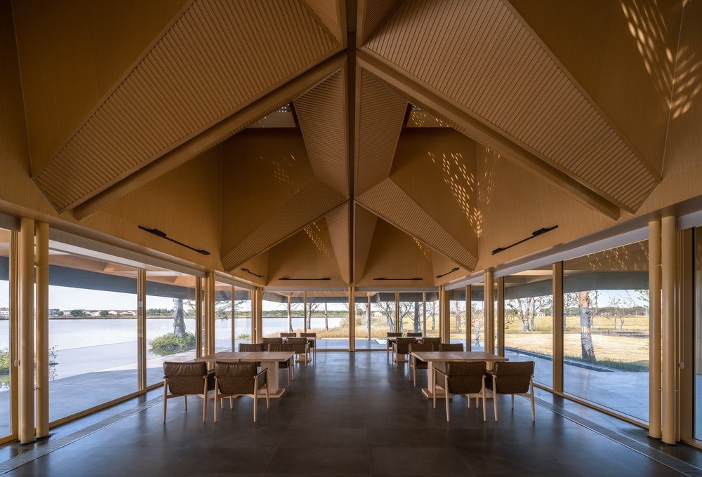 L'intérieur vitré du bâtiment. Une terrasse extérieure couverte est aménagée autour de l'espace intérieur.