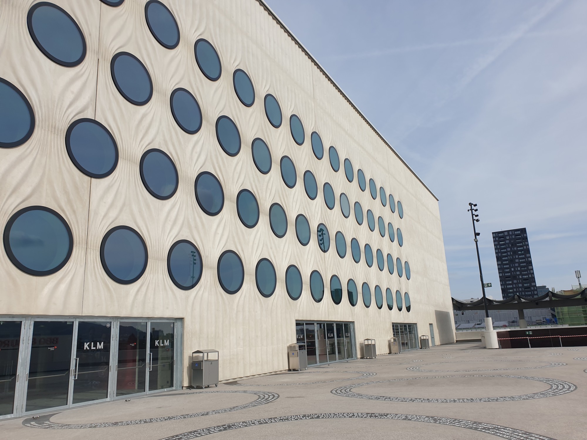 La façade de la Swiss Life Arena de Zurich se déploie comme un rideau drapé autour du bâtiment. Les fenêtres arrondies se veulent un clin d'oeil aux pucks des hockeyeurs.