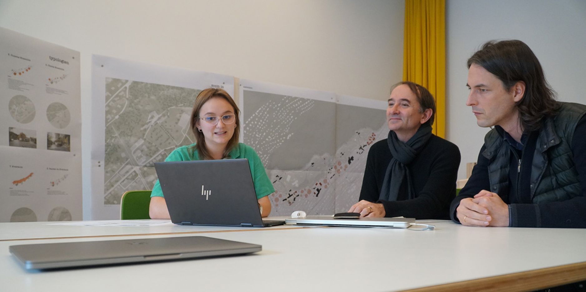 Tobias Baitsch (à droite) et Stanislas Zimmermann discutent avec Céline Zufferey de son travail de master sur l'étude de nouvelles formes de logement en Suisse.