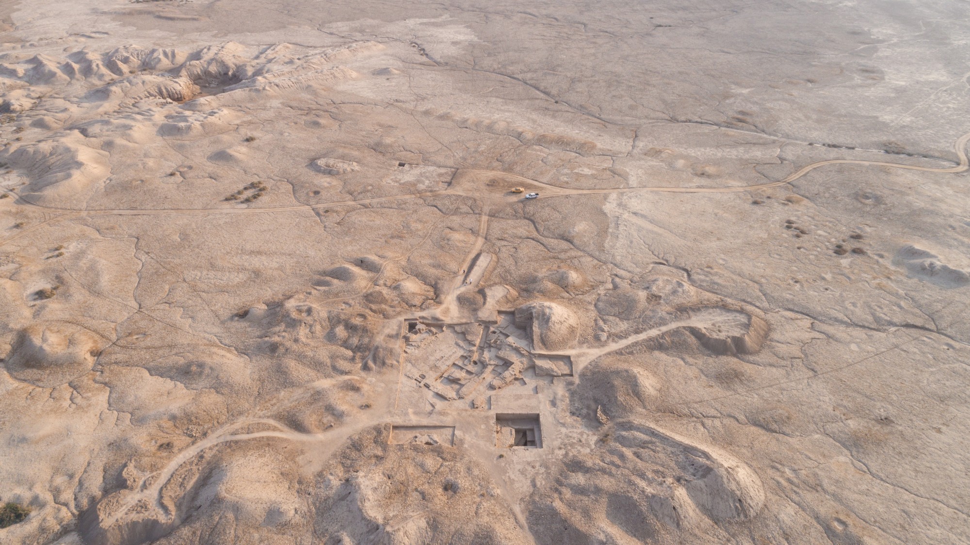 Vue aérienne de la colline du temple de Girsu, vue vers le sud, avec l'enceinte sacrée entourée de murs en arrière-plan.