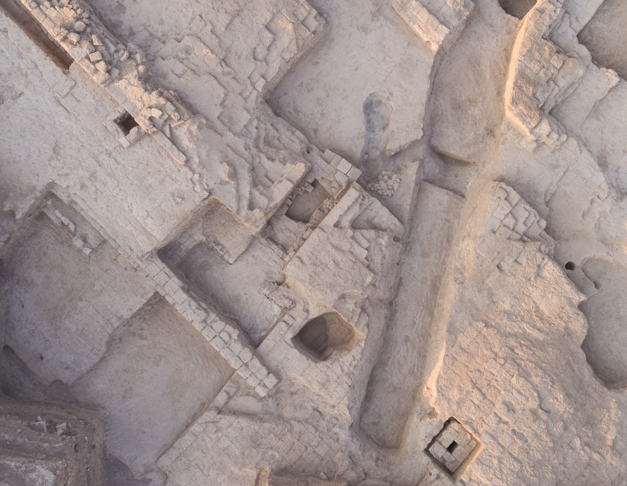 Vue aérienne des fouilles françaises menées sur la colline du temple au XIXe et au début du XXe siècle. On peut y voir de vastes fossés en rampe et de grandes fosses horizontales, ainsi qu'un long fossé étroit et profond allant du nord au sud et quelques 