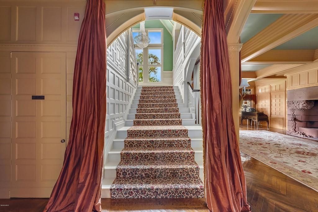 Un escalier luxueux et illuminé mène aux étages supérieurs de la demeure.