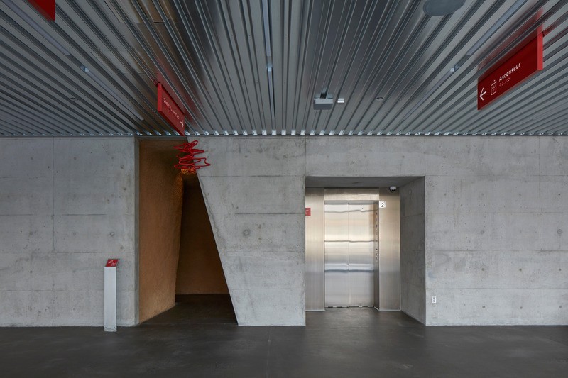 L'entrée du labyrinthe emmène les visiteurs sur un chemin descendant incurvé et aux parois inclinées.