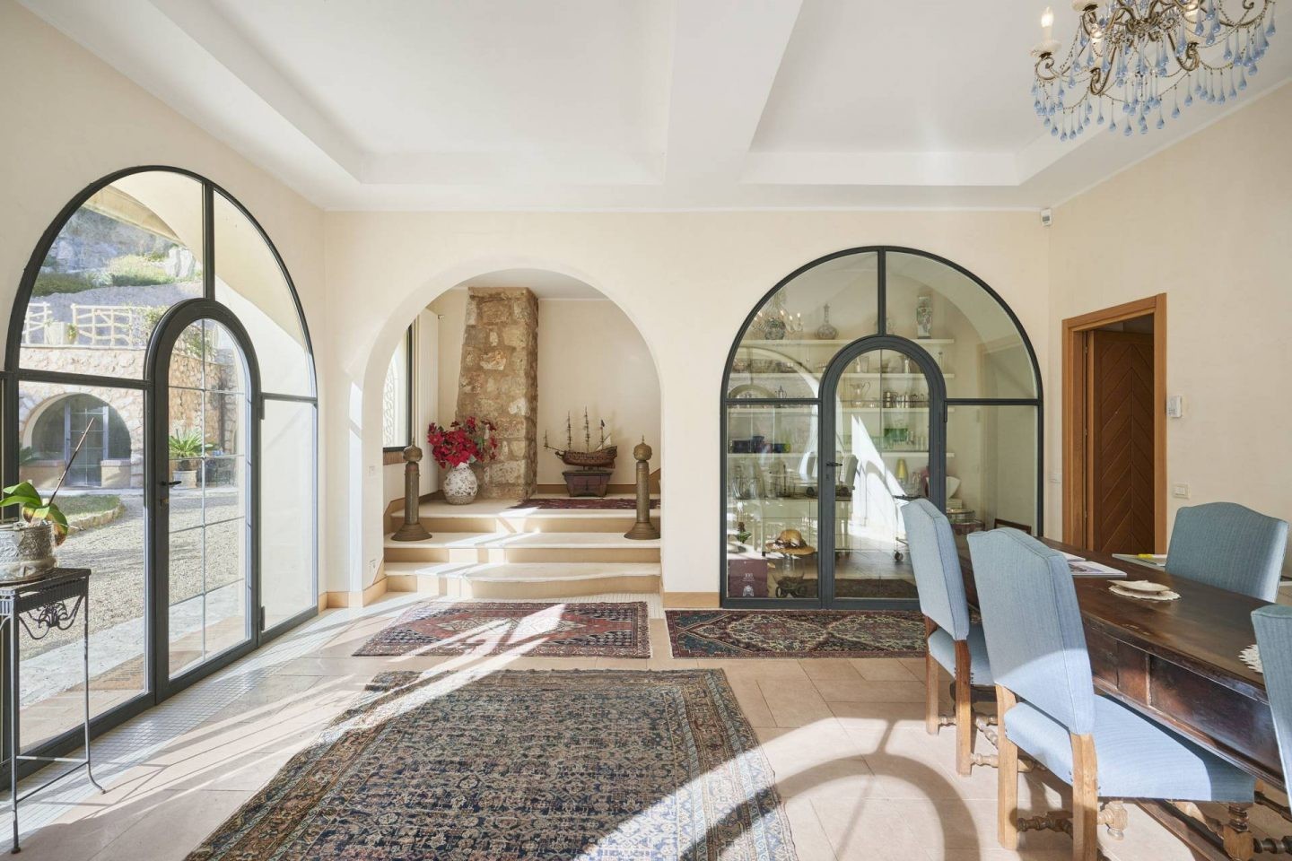 Les fenêtres cintrées laissent entrer beaucoup de lumière dans le salon de la luxueuse demeure.