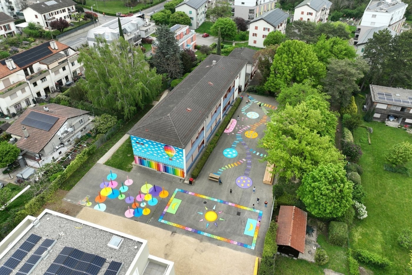 La cour de l'école de la Paix transformée par Nicolas Balmert, alias L'Original. L'objectif est de promouvoir l'interaction des enfants avec leur environnement par le biais d'une approche ludique, s'appuyant sur des éléments symboliques tels que la terre,