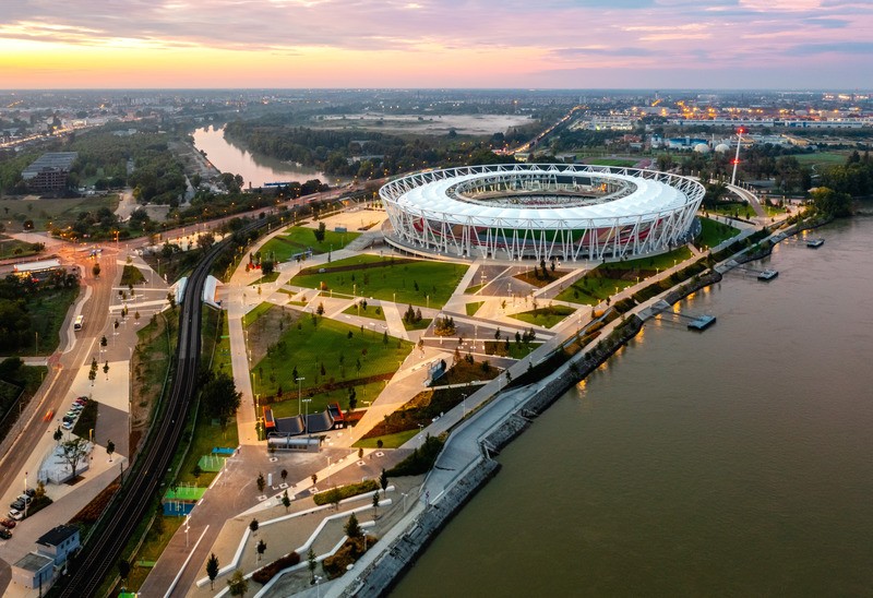 Le Centre National d’Athlétisme a été commandé par l’Etat hongrois comme point de départ du projet d’aménagement urbain à long terme de la Porte sud de Budapest. Le stade a été conçu par le cabinet d’architectes NAPUR Architect Kft., lauréat du concours.