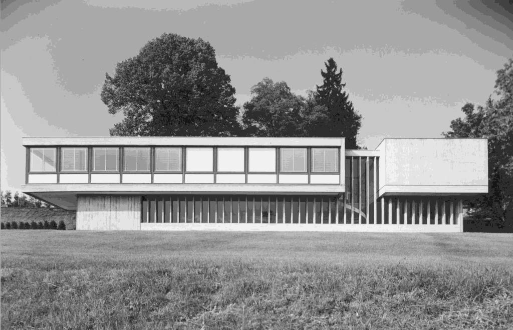 Construite en 1962 à Lancy sur un terrain en forte pente, face à la gare de la Praille, cette villa, inscrite à l’inventaire des bâtiments dignes de protection, se présente comme un objet à la volumétrie puissante dont la modernité s’affirme avec éclat. E