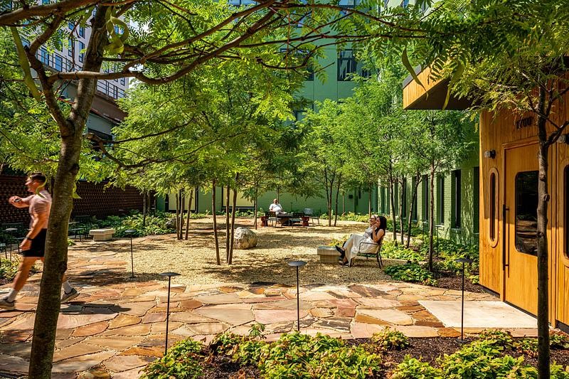 Une cour accueillante relie naturellement l’entrée principale à la rue et offre un havre de verdure.