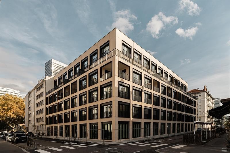 La façade du projet Manufacture à Lyon révèle le rythme régulier d’une trame structurelle unifiée.