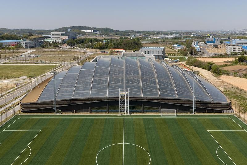 Le stade couvert vu d’en haut, mettant en valeur son volume compact et sa géométrie fonctionnelle.