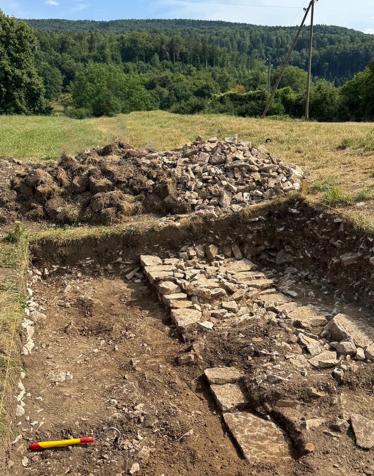 Vue nord du site où apparaît clairement le mur mis au jour sous la levée de terre, révélant une structure défensive attribuée à la guerre de Trente Ans.