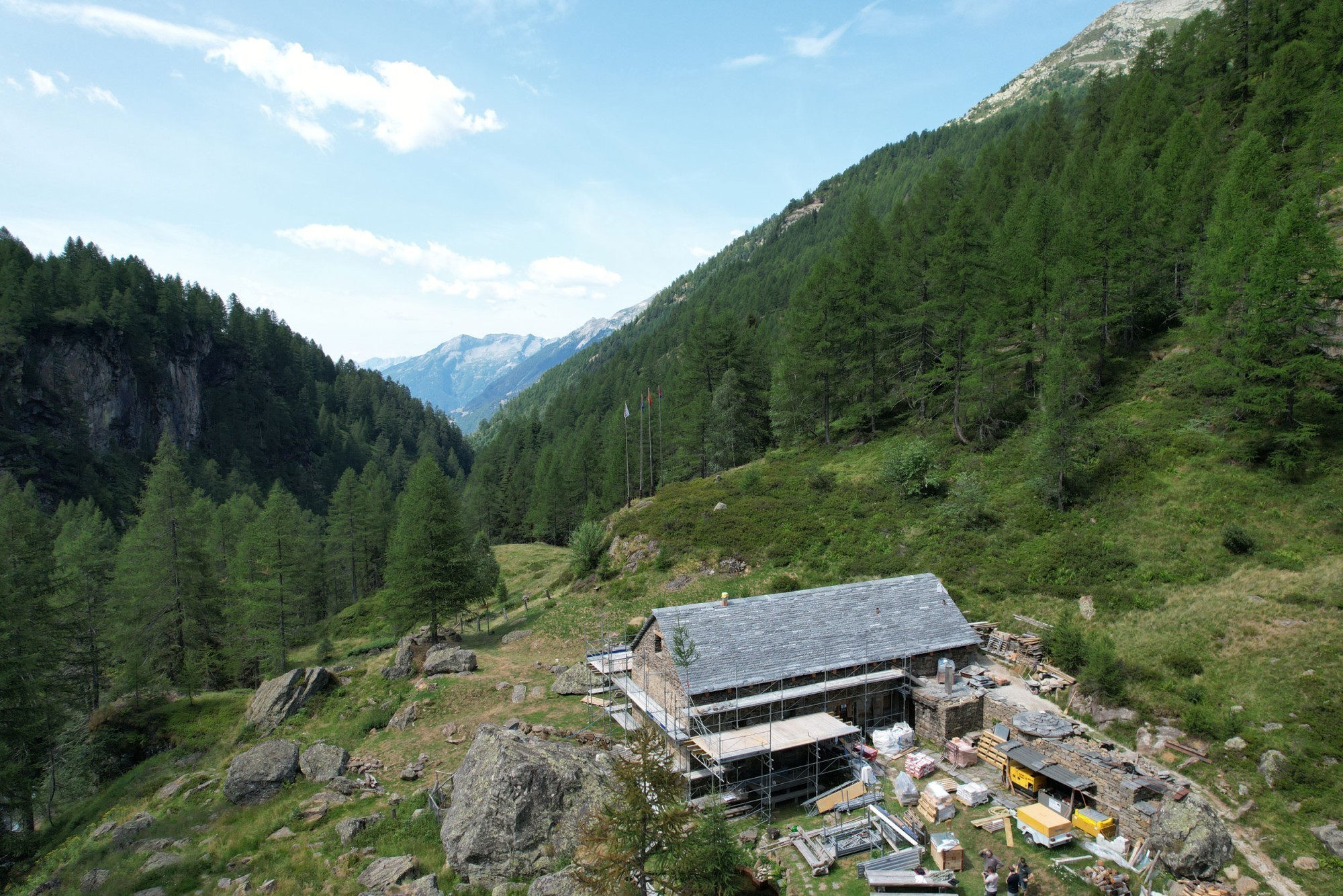 La situation en haute montagne pose des défis logistiques: tous les matériaux de construction doivent être acheminés jusqu'au refuge soit à pied, soit par hélicoptère.