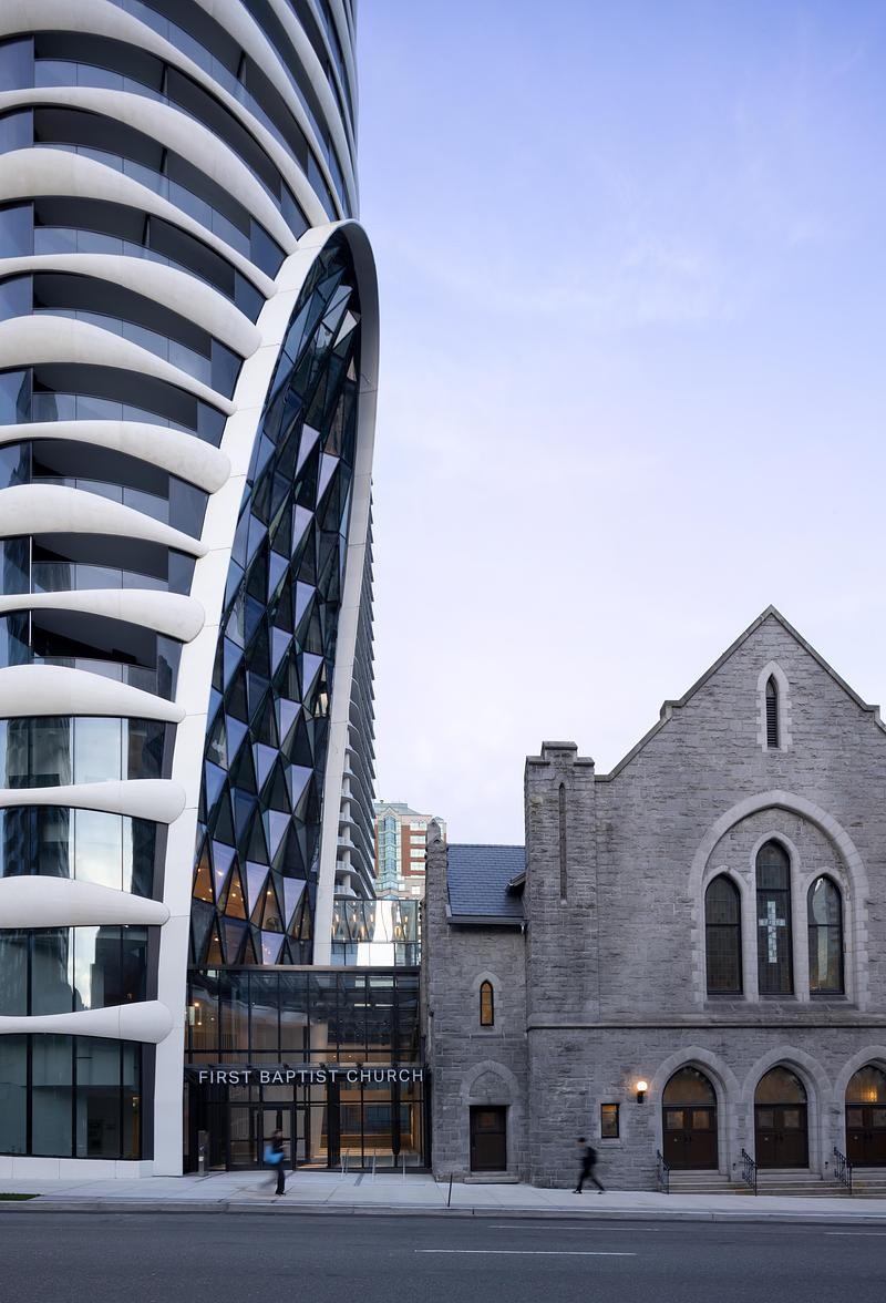 L’entrée vitrée reliant The Butterfly à la First Baptist Church met en scène la rencontre entre architecture contemporaine et patrimoine néo‑gothique au cœur de Vancouver.