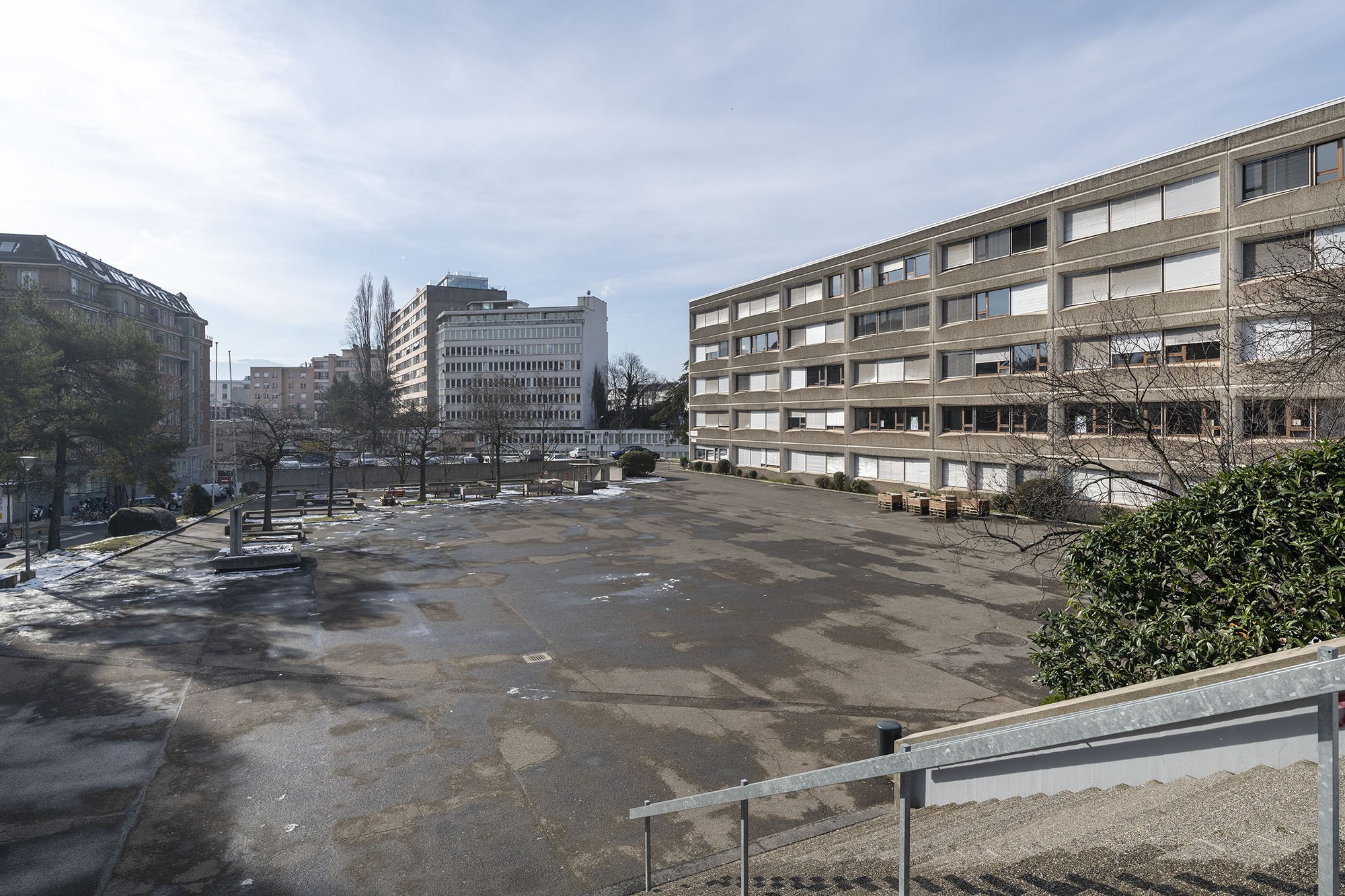 Le préau avant la rénovation, dominé par le bitume et dépourvu de végétation.