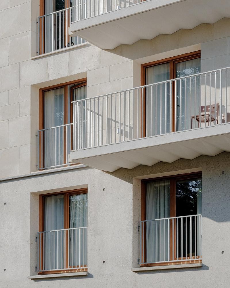 Les balcons soulignent la verticalité du bâtiment tout en offrant des espaces extérieurs privatifs.
