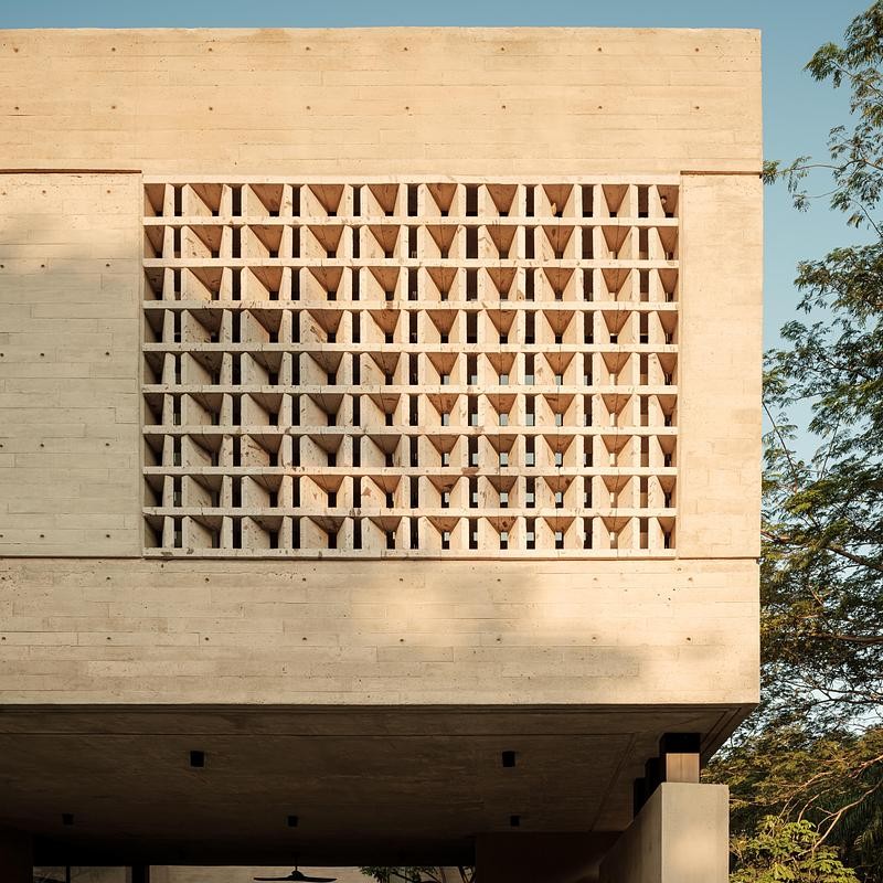 Les claustras en béton filtrent la lumière naturelle et projettent un jeu d'ombres évolutif sur les surfaces.