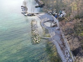 130 m de rive et digue adjacente au port ont été réaménagés en plage de galets et une digue sous-lacustre brise l'énergie des vagues du site très exposé à la bise.