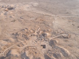 Vue aérienne de la colline du temple de Girsu, vue vers le sud, avec l'enceinte sacrée entourée de murs en arrière-plan.