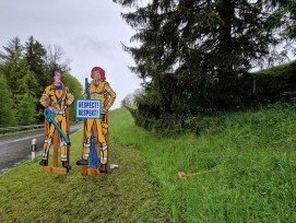 Ces figures représentent une cantonnière et un cantonnier en super héros de bande dessinée. Elles sont destinées à mettre en évidence le courage et la détermination nécessaires au travail des ouvriers de la route, 24 heures sur 24 et par tous les temps.