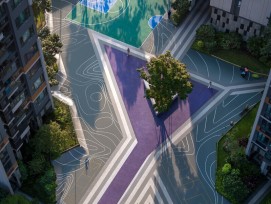 Vue plongeante sur le le long du chemin violet des Résidences Buji, bordé de rayures diagonales grises et blanches qui traversent la cour verdoyante.