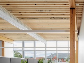 Le bois a été utilisé pour ses qualités structurelles, esthétiques et acoustiques. Le profil rainuré (ou en dents de scie) conçu pour les plafonds absorbe davantage le son qu'une surface plane, tout en ajoutant une composition architecturale rythmée.