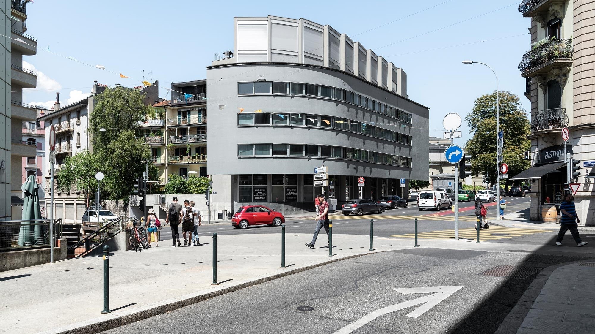 Cet immeuble genevois pour étudiants en forme de «L» s’adapte de tous les côtés à son contexte. Sur la cour et la rue latérale tranquille, ses grands vitrages reprennent le rythme ordonné des maisons voisines. Sur le boulevard à forte circulation, il prés